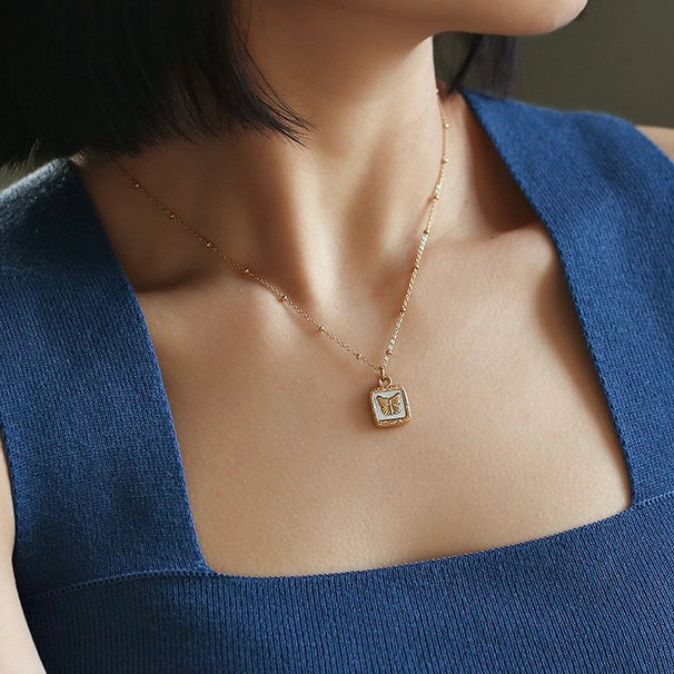 Close-up of Madelyn Butterfly and Shell Necklace on a Woman's Neck