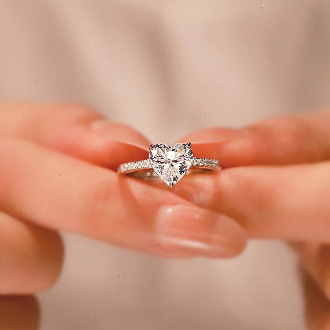 Close-up of the Sophie Heart Ring, a romantic heart-shaped gemstone ring, showcasing a shimmering gemstone at its center.