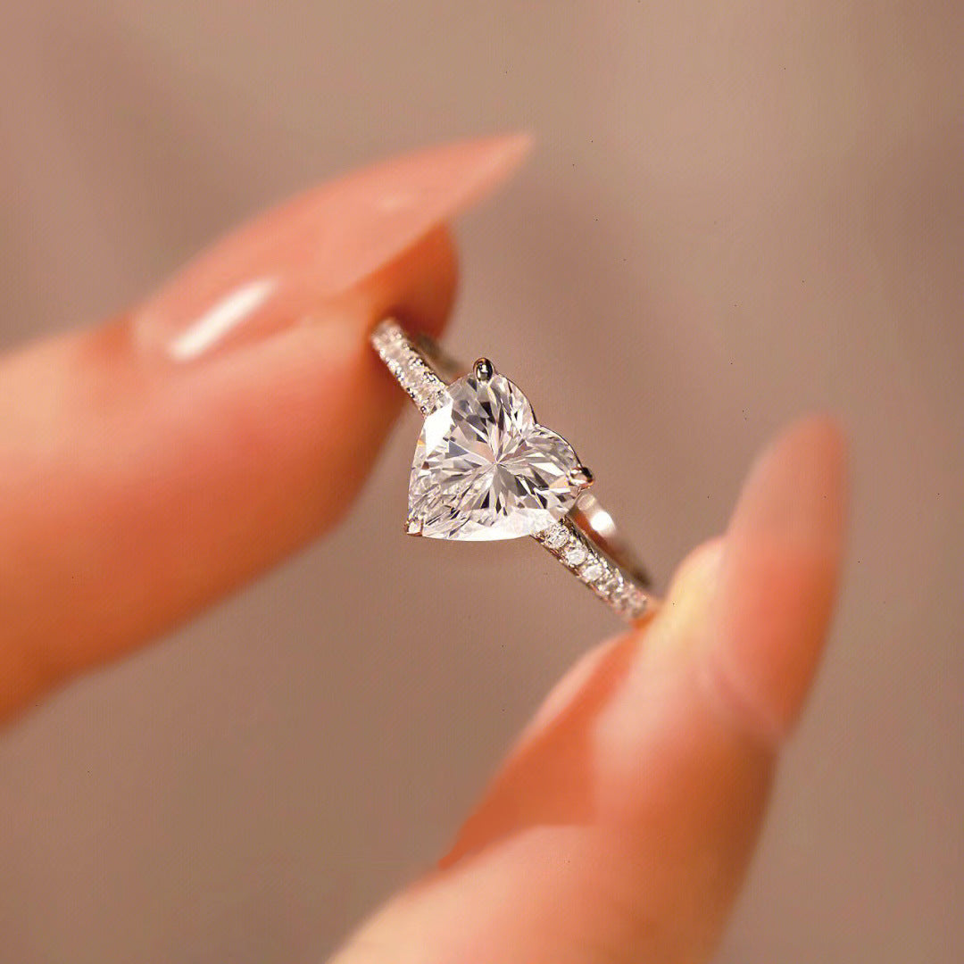 Close-up of the Sophie Heart Ring, a romantic heart-shaped gemstone ring, showcasing a shimmering gemstone at its center.