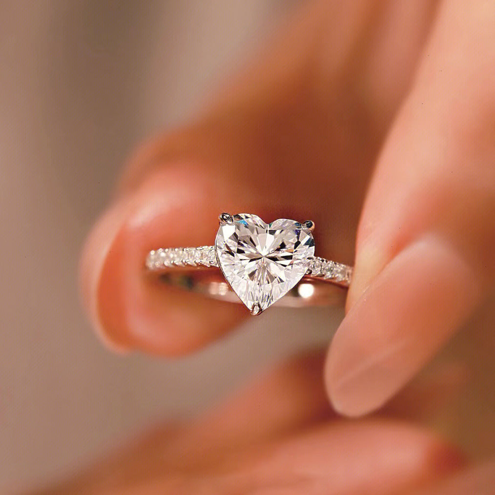 Close-up of the Sophie Heart Ring, a romantic heart-shaped gemstone ring, showcasing a shimmering gemstone at its center.