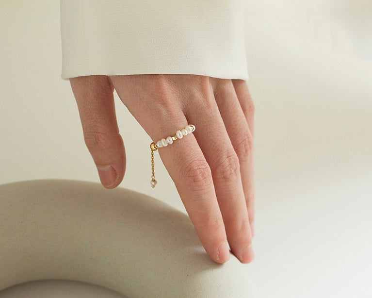 A hand wearing the elegant Callie Pearl Chain Adjustable Ring - LuvEcho Jewelry