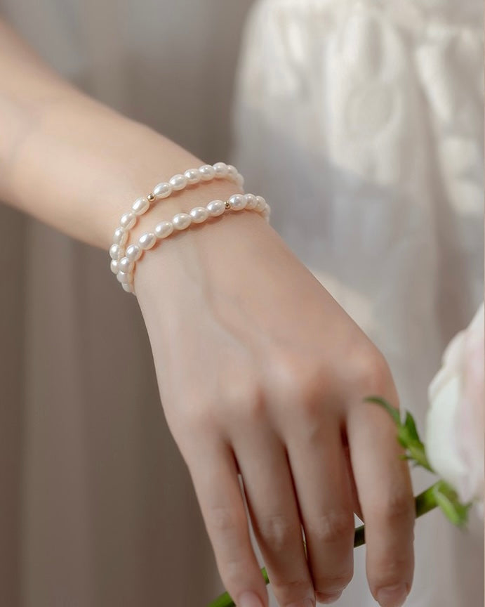 A model wearing the elegant Aurora Gold Beads Glare Freshwater Pearl Bracelet on her wrist.