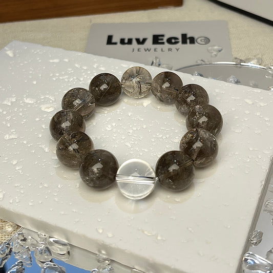 Protective energy Azeztulite bracelet featuring 14mm smoky beads and a crystal quartz bead for clarity.




