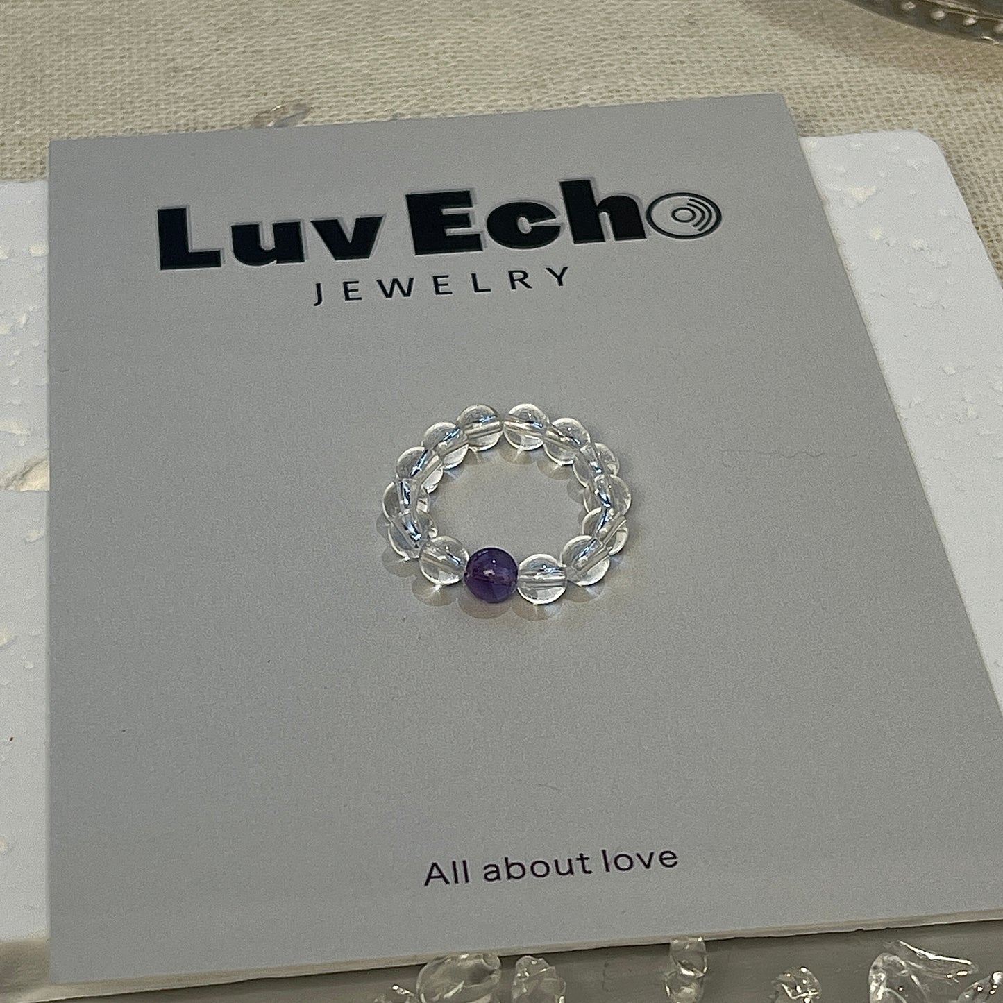 Handcrafted crystal quartz beaded ring with a central amethyst stone.