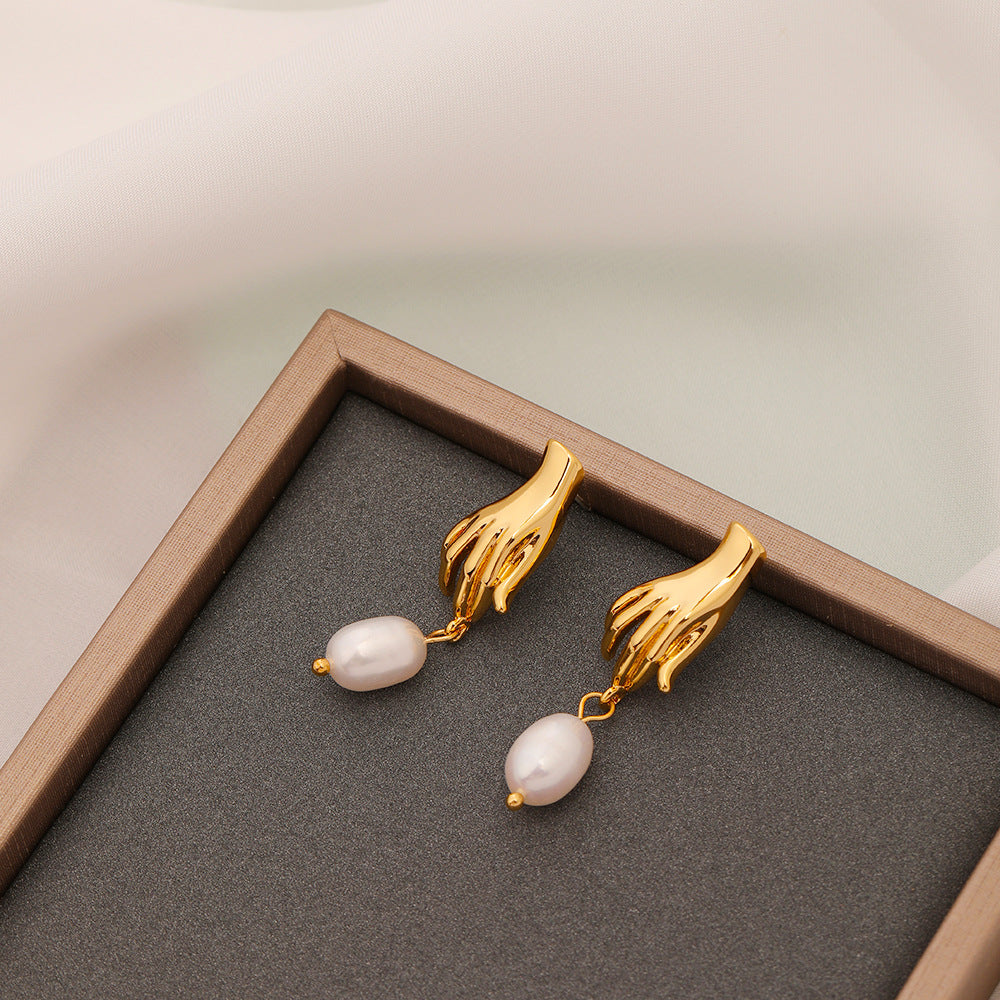 Luv Echo Jewelry - Hadley small hand baroque pearl stud earrings in gold color, featuring a hand-shaped design with a single baroque pearl in the center.