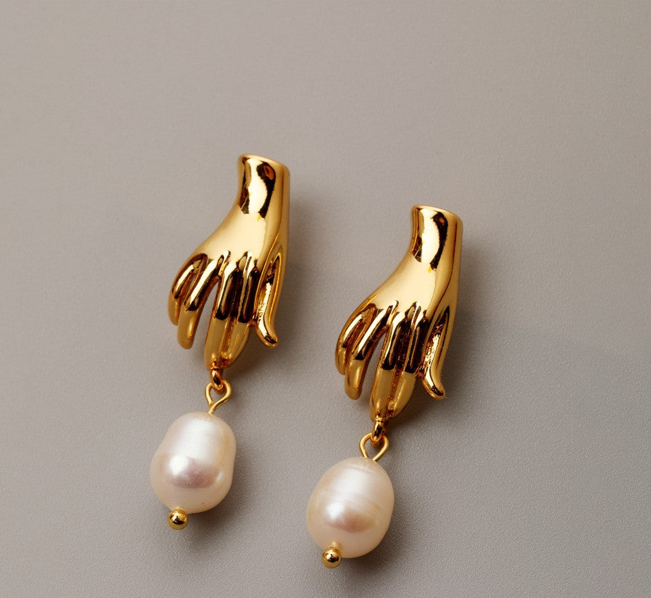 Luv Echo Jewelry - Hadley small hand baroque pearl stud earrings in gold color, featuring a hand-shaped design with a single baroque pearl in the center.