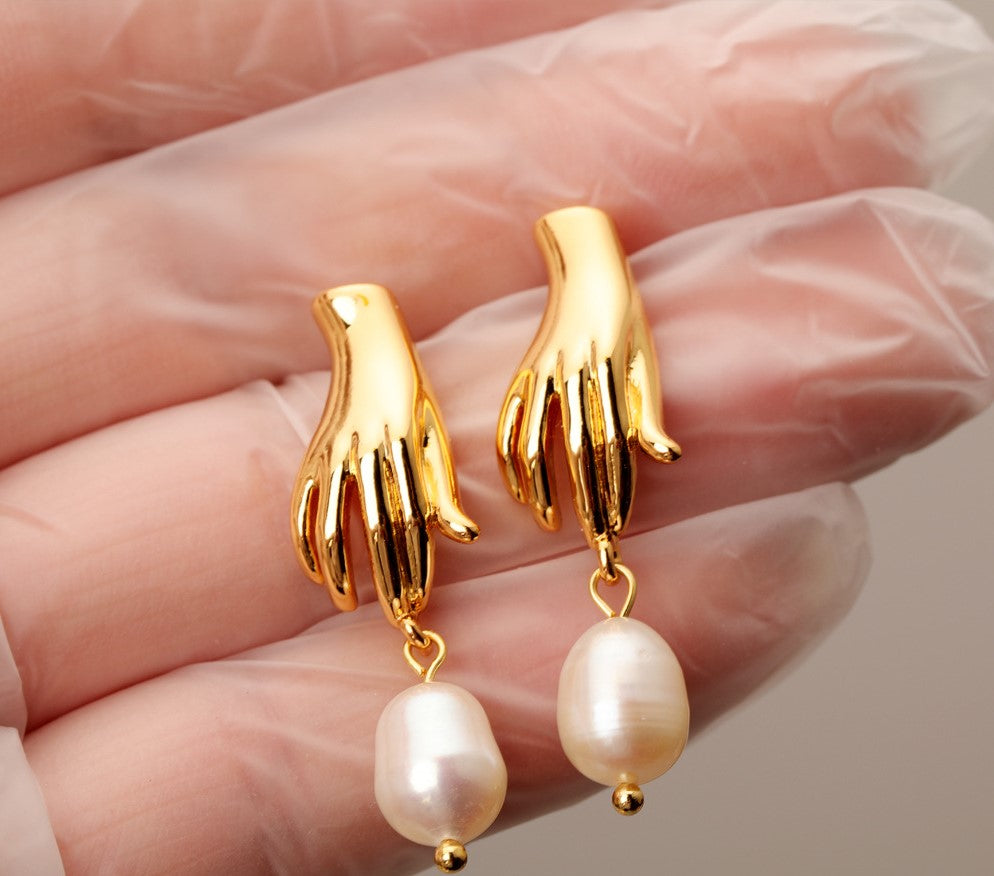 Luv Echo Jewelry - Hadley small hand baroque pearl stud earrings in gold color, featuring a hand-shaped design with a single baroque pearl in the center.